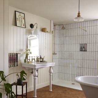 white tiled bathroom with wood floors