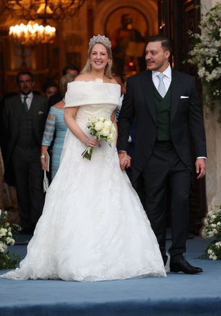 Princess Theodora of Greece wears a tiara and white wedding gown as she holds hands with new husband Matthew Kumar, who wears a smart suit following their wedding in Athens, Greece on September 28, 2024