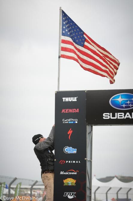 Race Director Jeff Frost raises the US flag for the singing of the national anthem