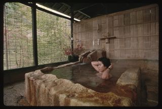 A woman bathing in a Japanese onsen bath