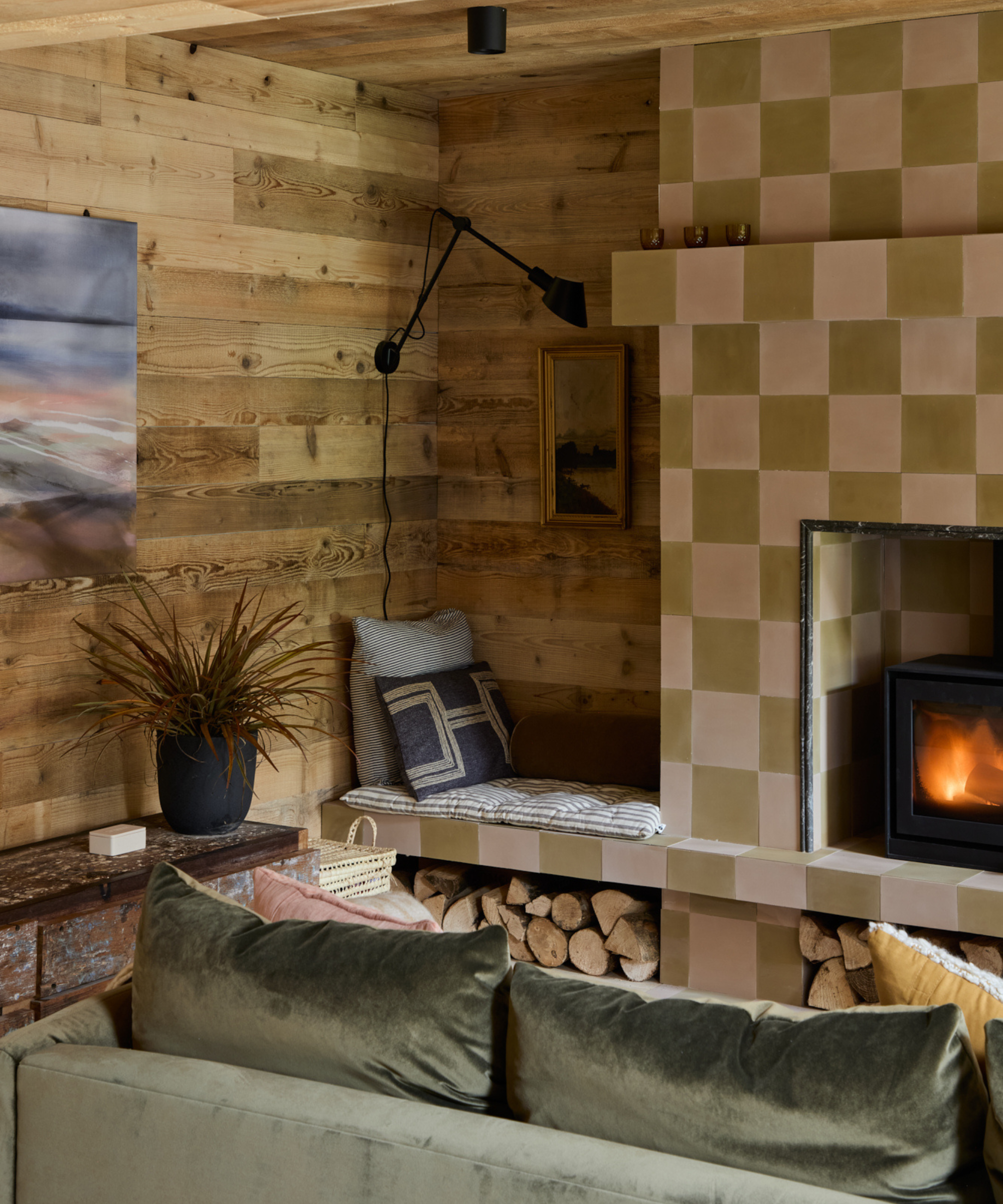 Living room with tiled fireplace and a seating nook above a log store shelf