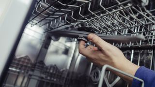 Man removing dishwasher spray arm