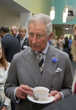 Prince Charles, Prince of Wales drinks a cup of tea during a visit to a Marie Curie Cancer Care Hospice on June 21, 2013 in Solihull, United Kingdom.