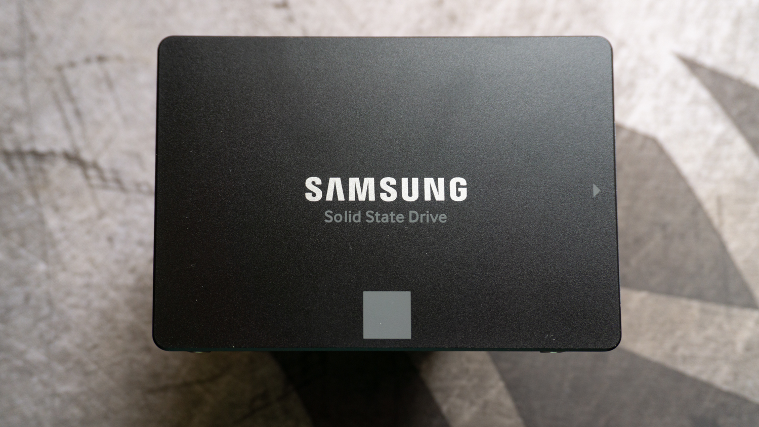Musta Samsung 870 Evo SSD harmaalla kangasalustalla
