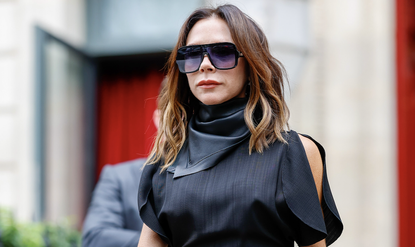 Victoria Beckham checking out of her hotel during the Womenswear Spring/Summer 2025 as part of Paris Fashion Week on September 29, 2024 in Paris, France wearing a black dress and leather scarf