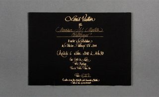 Back view of ﻿Louis Vuitton's invitation pictured against a grey background
