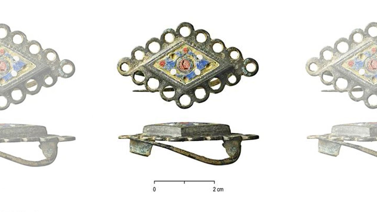 Other artifacts found include personal items like this enameled brooch, which may have been used to fasten a cloak.
