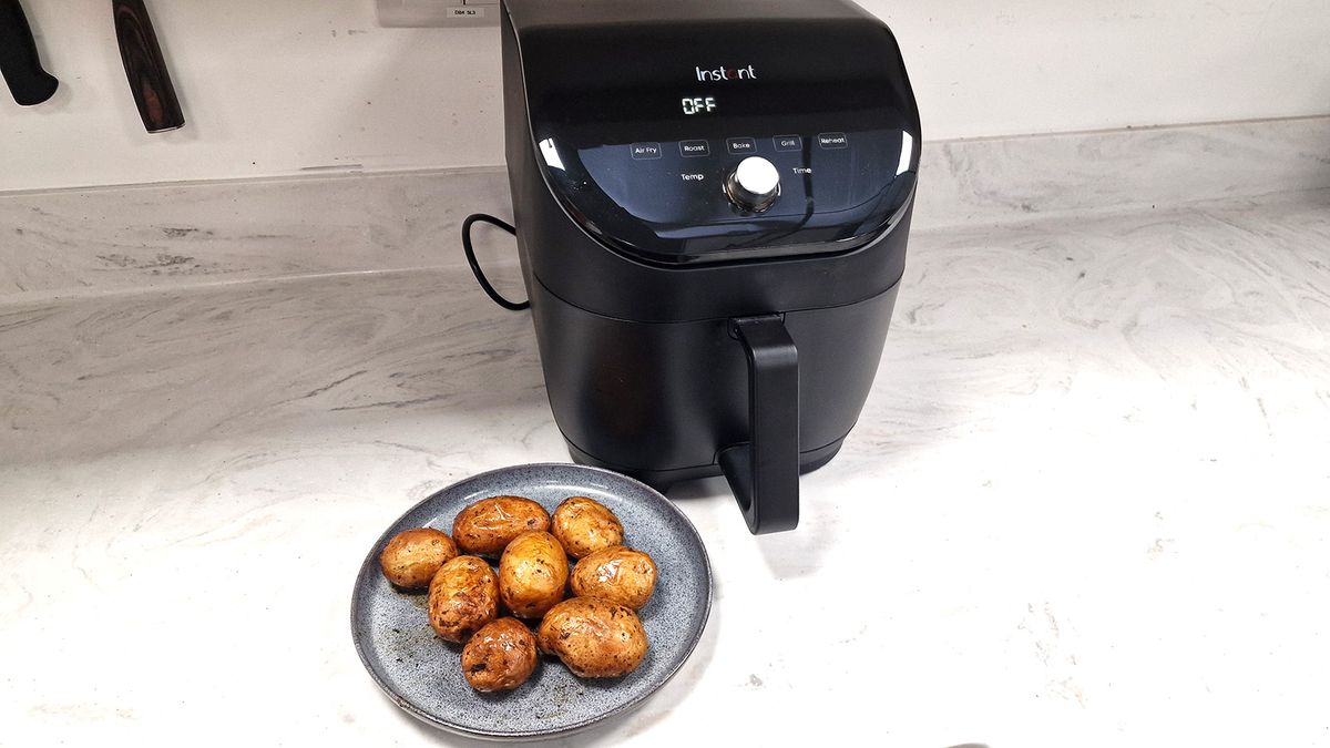 Instant Vortex Slim XL Air Fryer next to a plate of roasted potatoes