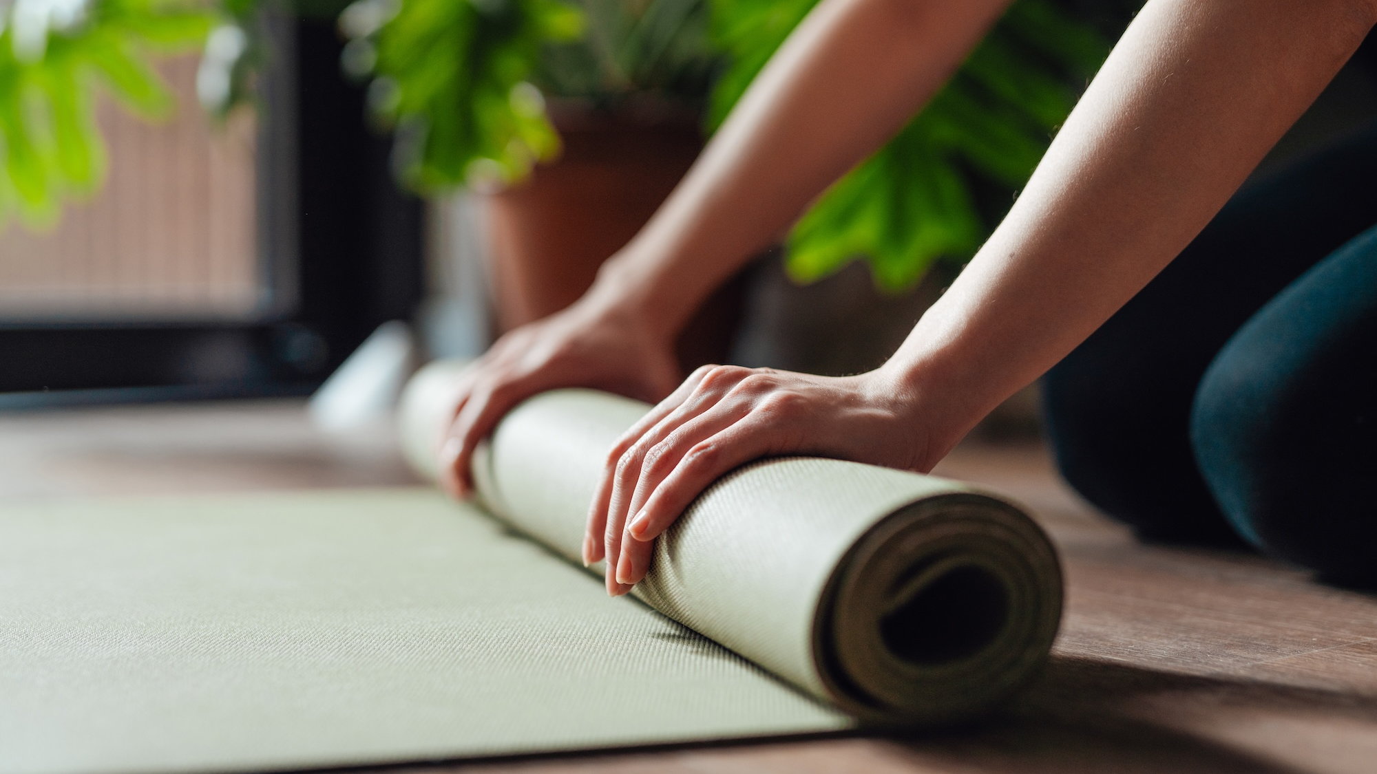 Woman rolling up a yoga mat