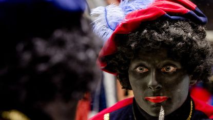 Woman has her face painted to become Zwarte Piet (Black Pete)