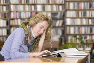 Young woman using tablet computer in library