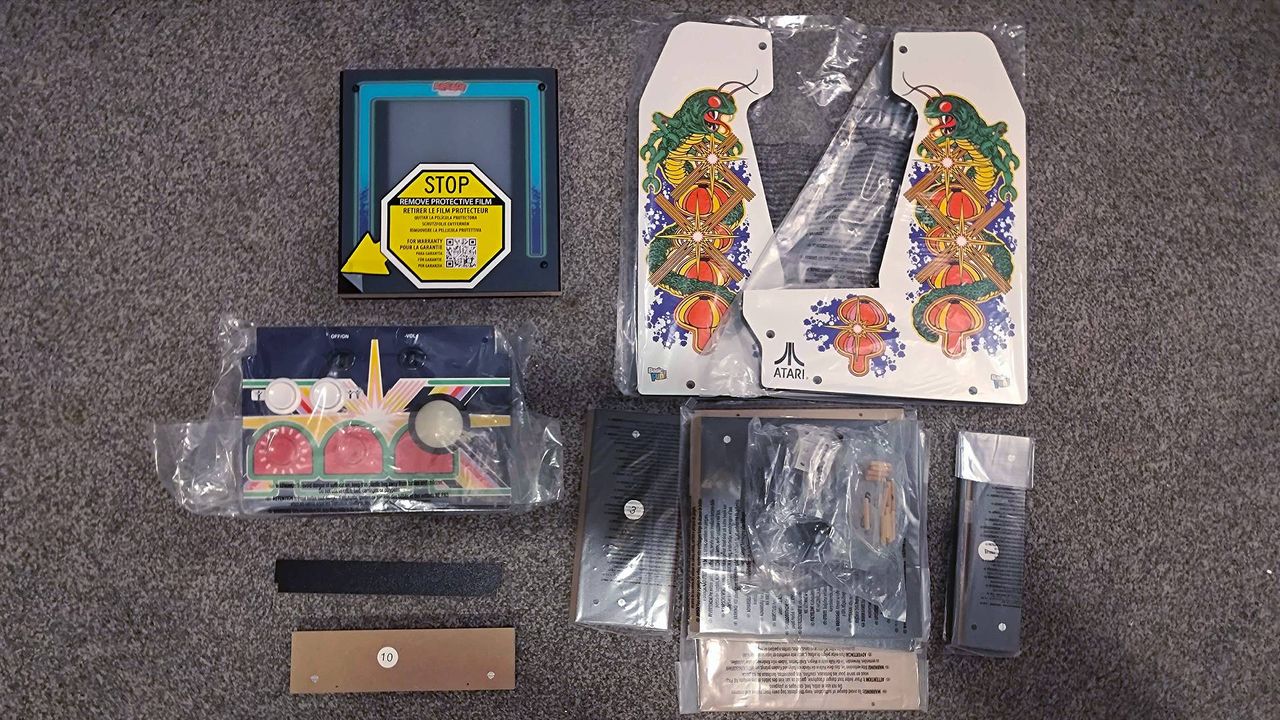 Arcade Classics Centipede contents on floor including side panels and screen.