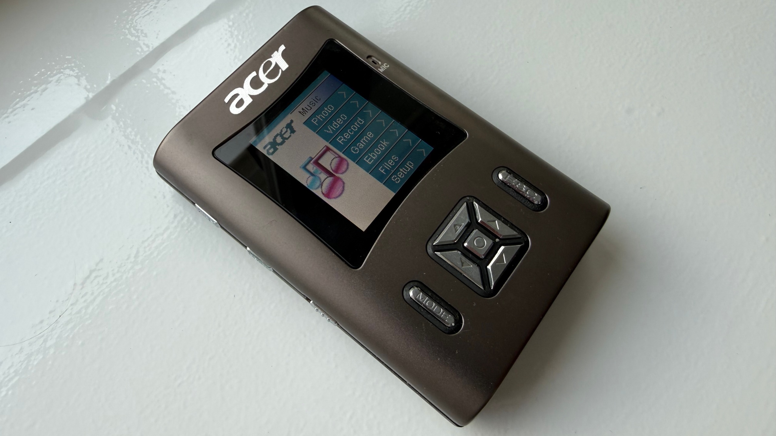 An Acer MP340 lying on a white surface at a 3/4 angle.
