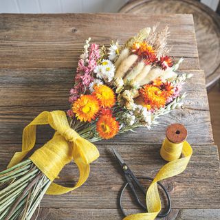 Colourful bunch of dried flowers tied with yellow ribbon