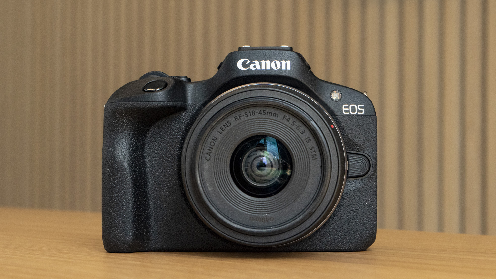 Canon EOS R100 camera on a table front view