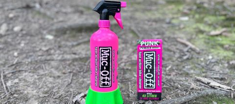 Detaiks of the Muc-Off Bottle for Life with its bright pink alloy bottle and green holder