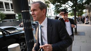 WASHINGTON, DC - SEPTEMBER 12: Kent Walker, President of Global Affairs at Google and Alphabet, trailed by Ian Madrigal dressed as the "Monopoly Man"departs federal court September 12, 2023 in Washington, DC. Google will defend its default-search deals in an antitrust trial against the Justice Department that began today.