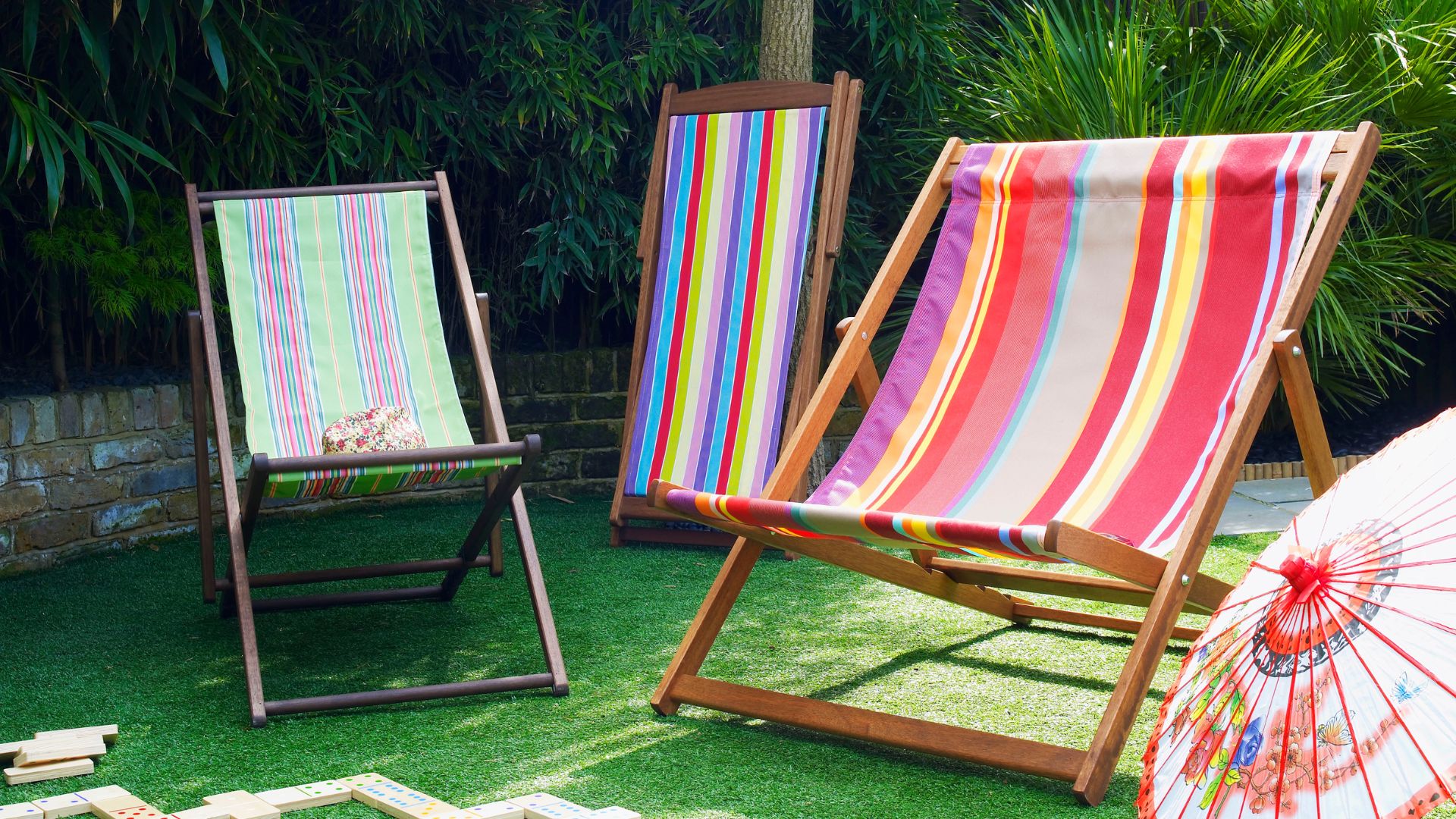 picture of three wooden and fabric deck chairs on grass