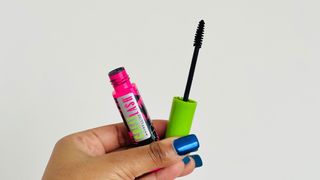 A person holding an open tube of the Maybelline Great Lash Mascara for the Maybelline Great Lash Mascara review.