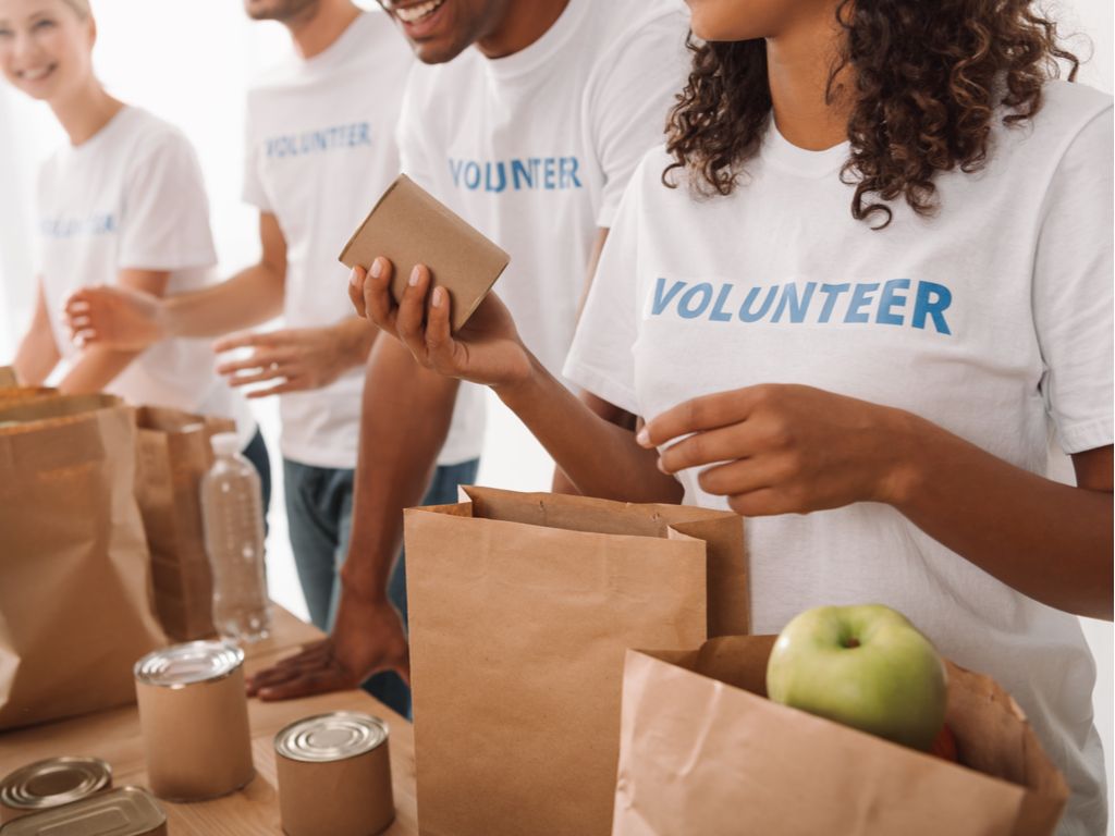 People volunteering to pack food in paper bags