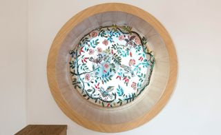 A round stained glass window with floral motives in the living space