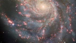 a spiral galaxy with a bright dot at one end