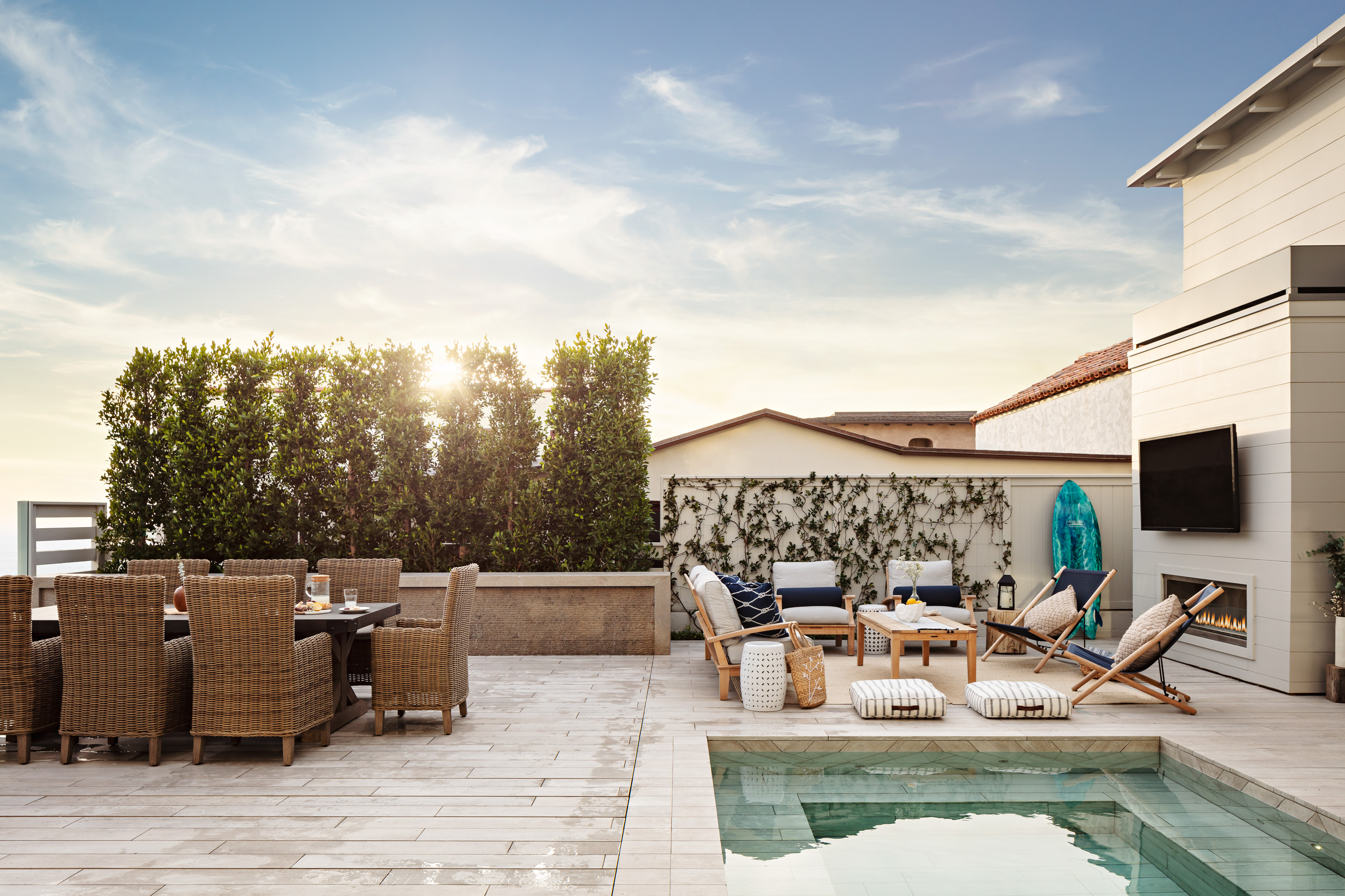 large patio area with a dining setup, a collection of deck chairs, and a small pool