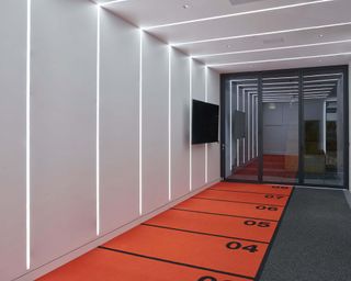 A home gym with red mat decor and overhead LED lighting