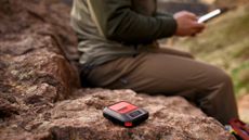 Photo of the Garmin InReach Messenger Plus and someone using it to send messages on their smartphone over satellite.