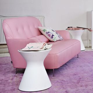 pink sofa and book on white stool