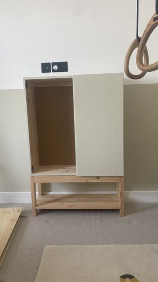 An IKEA IVAR painted light beige with an open cabinet door