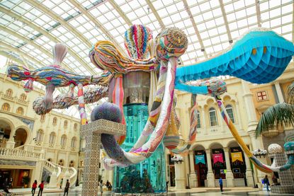 A multi-coloured patchwork octopus spreading its tentacles in the central plaza of the high ceiling central plaza of MGM Macau. 