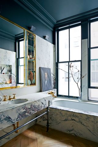 Bathroom with marble bath and vanity unit and a black ceiling
