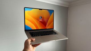 MacBook Air M2 being held up against a white wall