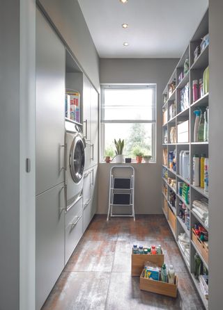 galley utility room by Schüller with open cupboards, drawers, a washing machine in an all-white finish