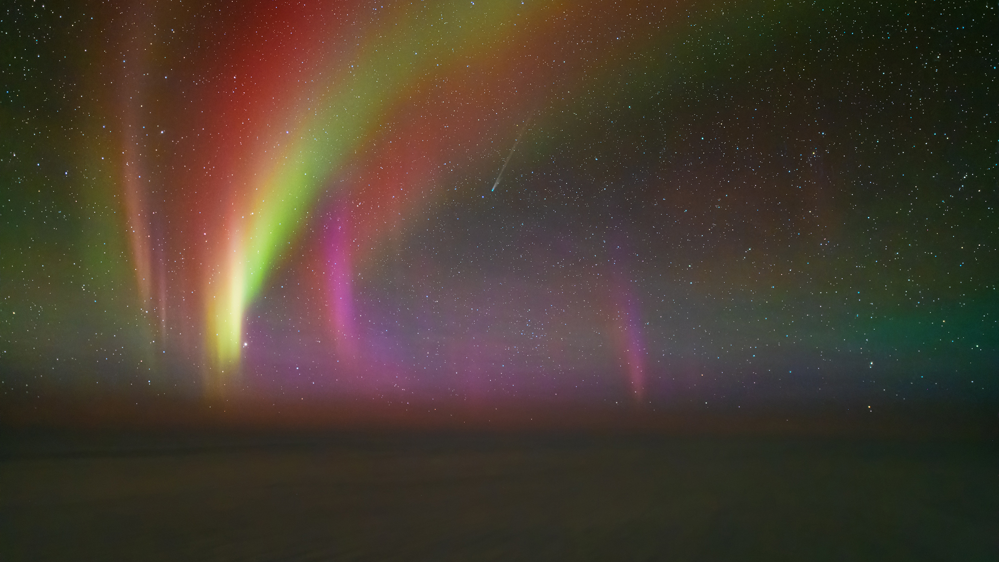 A photograph taken by pilot Ralf Rohner of the aurora with Comet Lemmon above the clouds