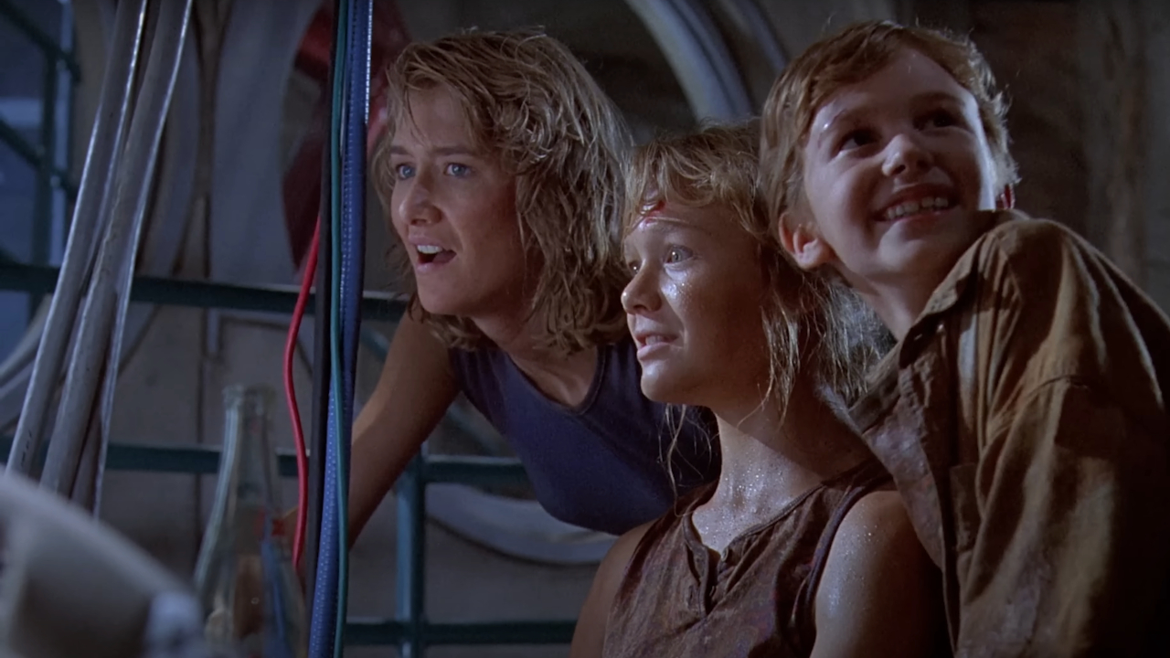 Laura Dern, Ariana Richards, and Joseph Mazzello stand relieved in Jurassic Park.