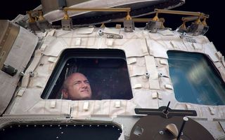 Astronaut Scott Kelly looks out of the space station's Cupola during his 340-day mission in space.