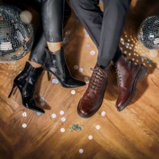 Pair of boots and heels sold at Jones Bootmaker on festive floor background