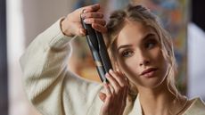 model curling her hair with cordless ghd tool - cordless ghds