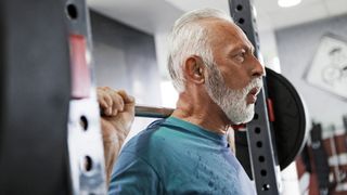 Older man doing a barbell squat