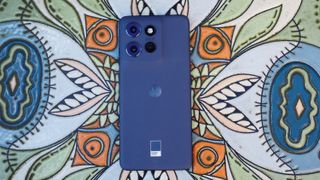 A blue Moto Edge 50 Neo on a flowery background