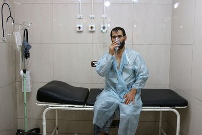 A Syrian man experiencing breathing troubles after monitors say Syrian government forces dropped chlorine in Aleppo.