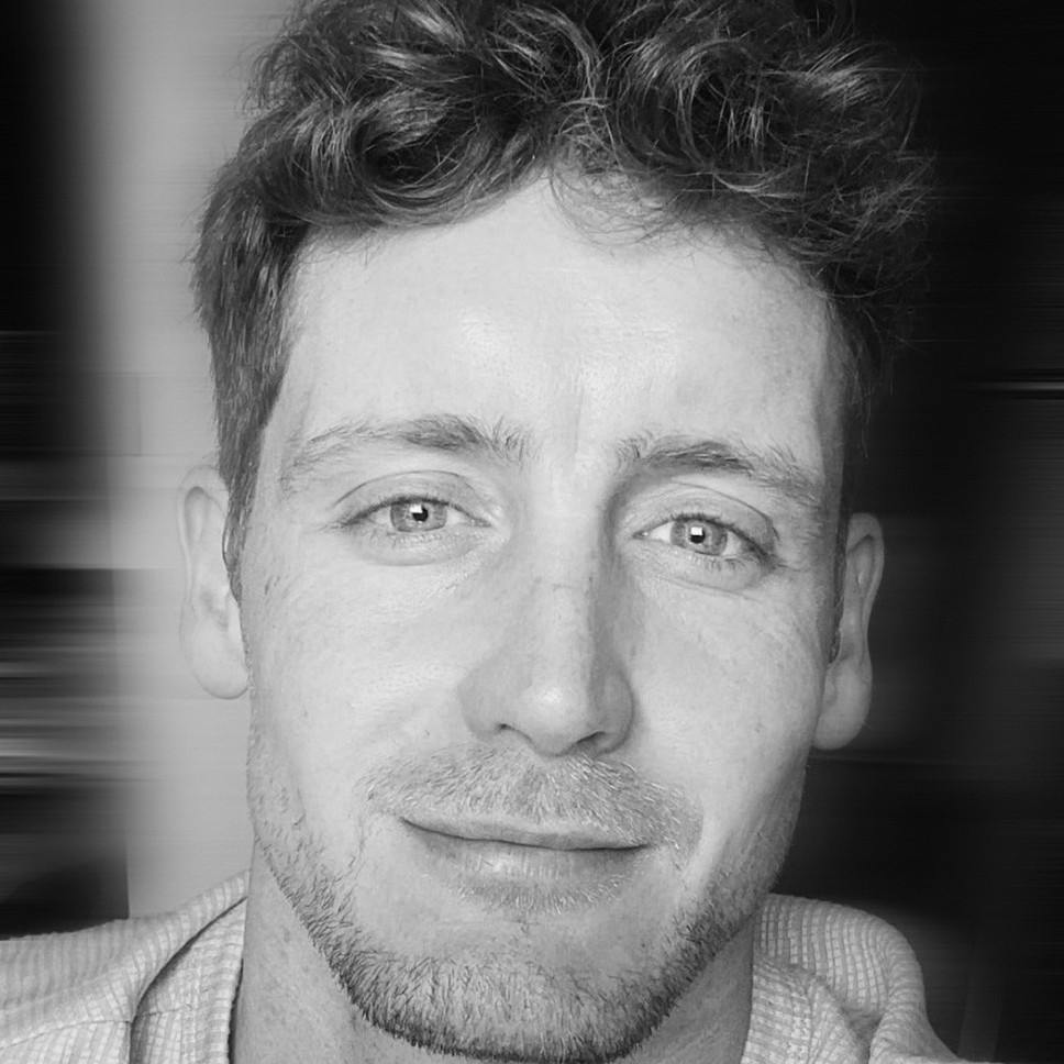 black and white image of male with dark hair and stubble