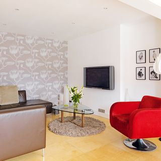 living room with wallpaper and red armchair