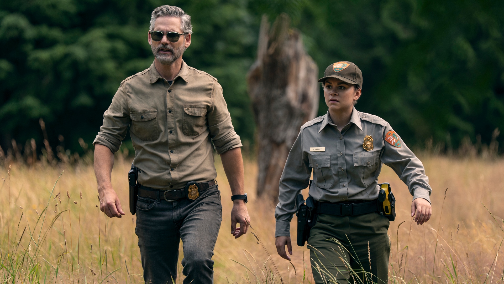 Kyle and Vasquez walk through tall grass in Untamed