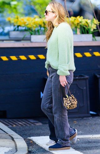 Jennifer Lawrence wearing a green sweater and leopard print bag