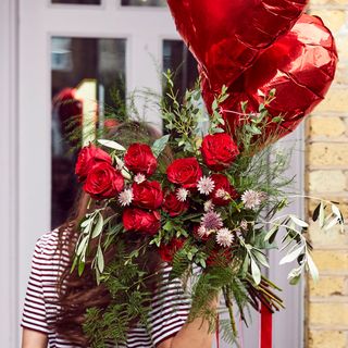 girl with red roses bouquet and red balloon