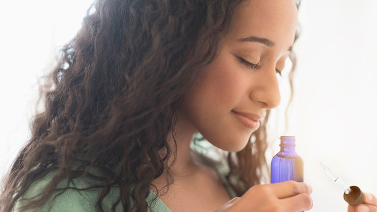 woman smelling essential oil bottle