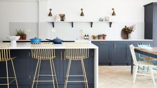 blue kitchen with island with seating and gold stools